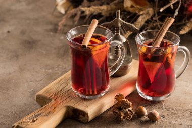İki bardak noel şarabı portakallı ve baharatlı ve dokusal bir arka planda. Seçici odaklanma. Boşluğu kopyala.