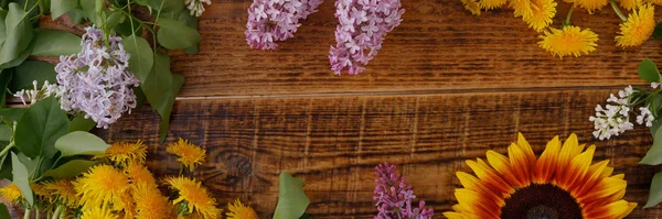 A dekoráció a virágok a háttérben a vintage fa deszkák. Vintage háttér virágok pitypang napraforgó és orgona és egy hely a szöveg alatt. Kilátás fentről. Lapos fekvés. Zászlós. — Stock Fotó