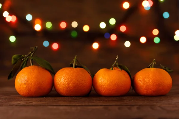 Ligne de rangée d'oranges mandarines pour Noël et Nouvel An sur fond bois. Conception de concept de vacances de fruits et de guirlandes colorées.Espace de copie . — Photo