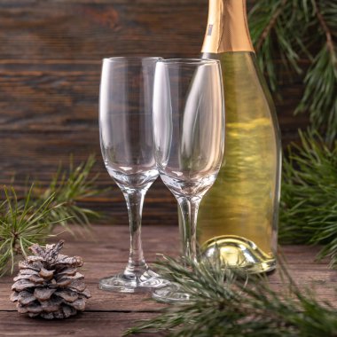 Şampanya için bardaklar ve yılbaşı dekorunun arka planında bir şişe. Uzayı kopyala Yakın plan..