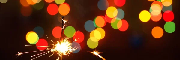 Gyönyörű csillagszórók egy koszorú hátterében. gyönyörű zászló az új évre. — Stock Fotó