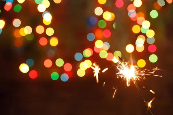 Wunderkerzen auf dem Hintergrund einer Girlande. schöne Urlaubskarte für das neue Jahr. — Stockfoto