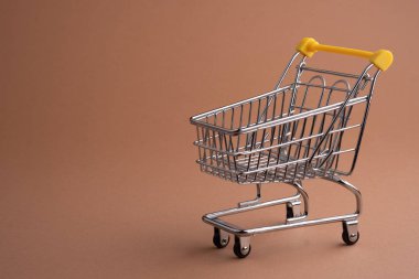 Kahverengi arka planda el arabası boş, Kara Cuma konsepti..