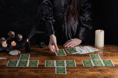 Female tells the future with playing cards. Tarot card concept on the table. Prediction of the future. Fortuneteller hands in black vestments.Psychic.