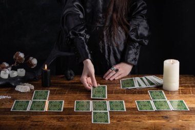 Female tells the future with playing cards. Tarot card concept on the table. Prediction of the future. Fortuneteller hands in black vestments.Psychic.