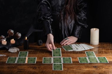 Female tells the future with playing cards. Tarot card concept on the table. Prediction of the future. Fortuneteller hands in black vestments.Psychic.