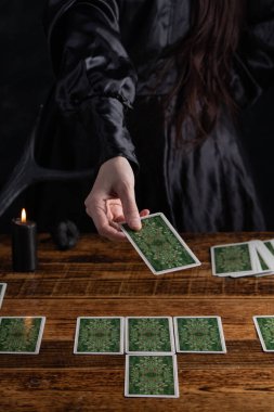 Female tells the future with playing cards. Tarot card concept on the table. Prediction of the future. Fortuneteller hands in black vestments.Psychic.