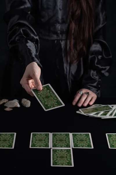 Female tells the future with playing cards. Tarot card concept on the table. Prediction of the future. Fortuneteller hands in black vestments.Psychic. — Stockfoto