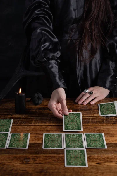 Female tells the future with playing cards. Tarot card concept on the table. Prediction of the future. Fortuneteller hands in black vestments.Psychic.