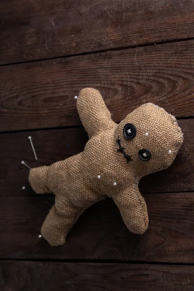 Muñeca vudú sobre fondo de madera con iluminación dramática. El concepto de brujería y arte negro. Muñeca de arpillera sobre fondo de madera. Pierce con mazas. Copiar espacio . —  Fotos de Stock