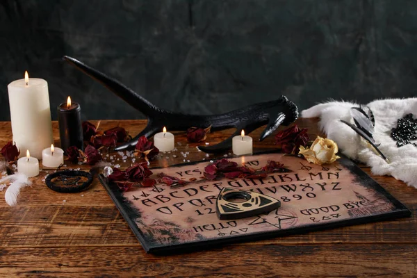 Ritual místico com Ouija e velas. Conceito de tabuleiro do diabo, magia negra ou rituais de adivinhação com símbolos ocultos e esotéricos . — Fotografia de Stock