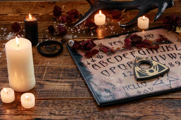 Mystic ritual with Ouija and candles. Devil's board concept, black magic or fortune telling rite with occult and esoteric symbols. — Stock Photo, Image