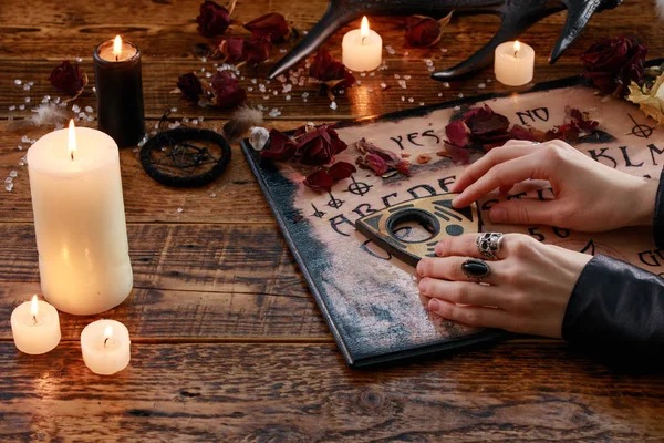 Ritual místico con tabla del Diablo y velas. La chica llama espíritus. La atmósfera mística del ocultismo y la magia negra . —  Fotos de Stock