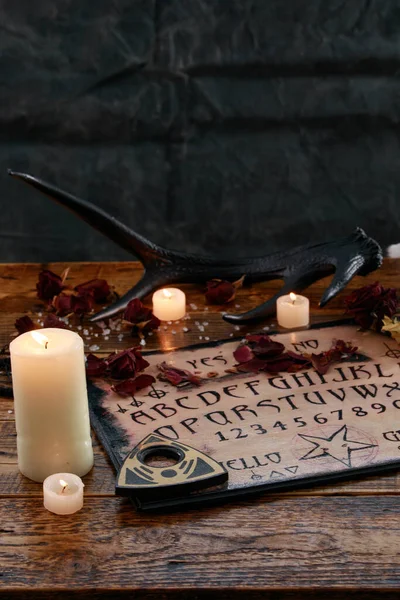 Mystic ritual with Ouija and candles. Devil's board concept, black magic or fortune telling rite with occult and esoteric symbols. — Stock Photo, Image