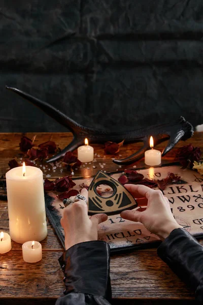 Mystic ritual with Devil's board and candles. The girl calls spirits.The mystical atmosphere of occultism and black magic. — Stock Photo, Image