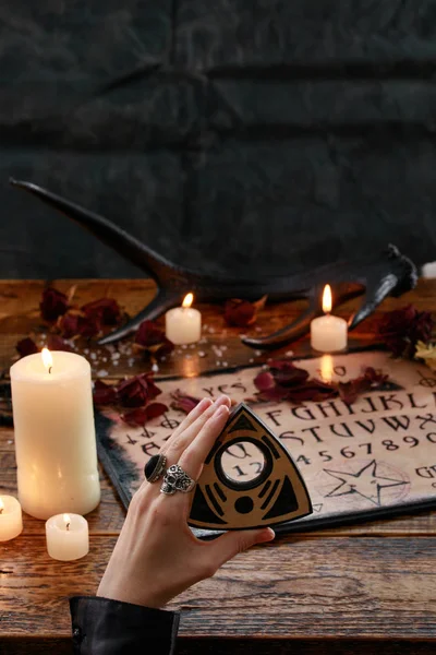 Rituale mistico con tavola del diavolo e candele. La ragazza chiama spiriti.La mistica atmosfera dell'occultismo e della magia nera . — Foto Stock