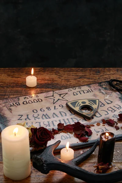 Ritual místico com Ouija e velas. Conceito de tabuleiro do diabo, magia negra ou rituais de adivinhação com símbolos ocultos e esotéricos . — Fotografia de Stock