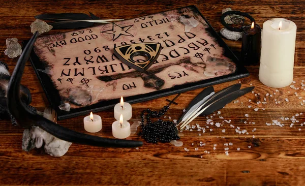 Tabuleiro Ouija com velas. Sente-se na mesa de madeira. A atmosfera mística do chamado dos espíritos. Magia negra . — Fotografia de Stock