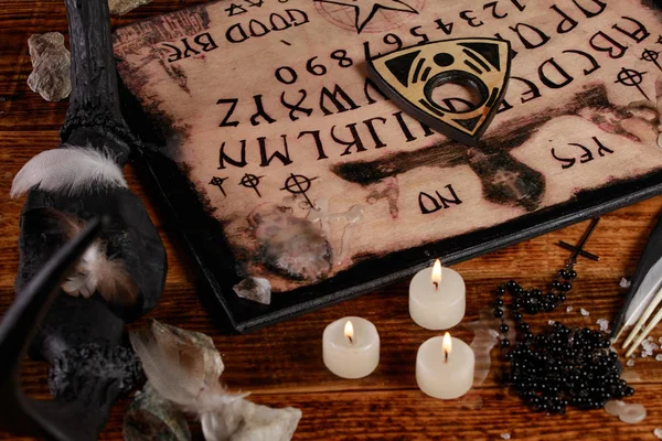 Ouija styrelse med ljus. Seans på träbord. Den mystiska atmosfären av andarnas rop. Svart magi. — Stockfoto