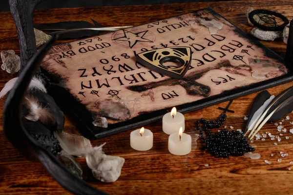 Ouija Board with candles. Seance on wooden table. The mystical atmosphere of the call of spirits. Black magic. — Stock Photo, Image