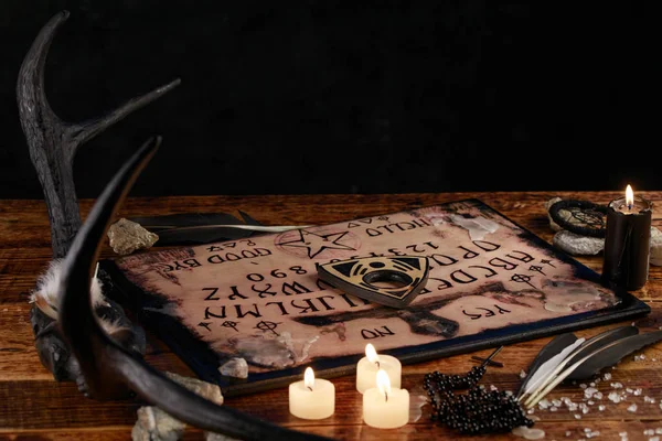 Ouija styrelse med ljus. Seans på träbord. Den mystiska atmosfären av andarnas rop. Svart magi. — Stockfoto