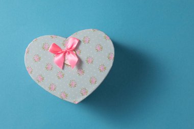 Sevgililer Günü kutlaması konsepti. Sevdiğin birinden güzel bir hediye. Yumuşak mavi arka planda fiyonklu bir boks. Uzayı kopyala Düz yatıyordu. Yakın plan..