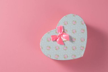 Sevgililer Günü kutlaması konsepti. Sevdiğin birinden güzel bir hediye. Hassas pembe arka planda fiyonklu bir kutu. Uzayı kopyala Düz yatıyordu. Yakın plan..