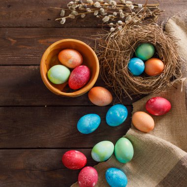 Ahşap bir arka planda kuş yuvasında paskalya yumurtaları. Taşralı. Doğal dekorasyon. Paskalya kutlaması. Uzayı kopyala Düz yatıyordu