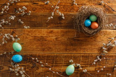 Ahşap bir arka planda kuş yuvasında paskalya yumurtaları. Taşralı. Paskalya kutlaması. Uzayı kopyala Düz yatıyordu