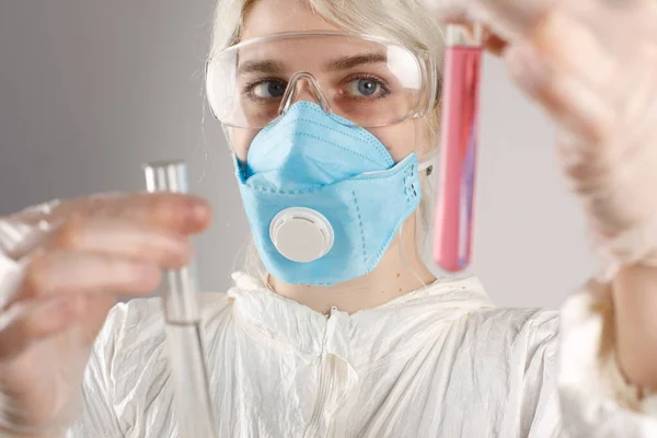 A girl in a protective suit and a respirator to protect health from viral, epidemic and infectious diseases. New Covid-19. Vaccine search concept. Stop the virus.