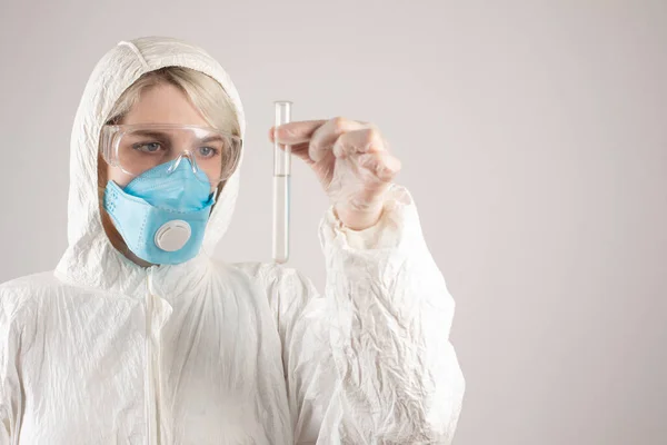 A girl in a protective suit and a respirator to protect health from viral, epidemic and infectious diseases. New Covid-19. Vaccine search concept. Stop the virus.