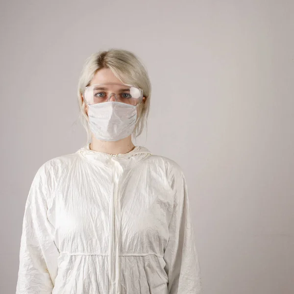 A girl in a protective suit and mask and glasses to protect health from viral, epidemic and infectious diseases. New Covid-19. Corona virus pandemic concept. Stop the virus.