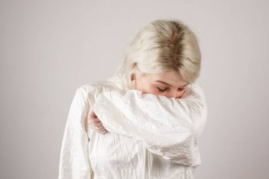 Kız, hava damlacıklarının yayılmasını önlemek için dirseğin kıvrımlarına hapşırır. Yeni Covid-19. Corona virüsü salgını konsepti. Virüsü durdur. Hijyen.