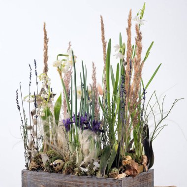 Güzel bir çiçek bahar düzenlemesi. Kurumuş çiçekler ve buketler için dekoratif bir kutuda taze çiçekler. Bahar konsepti ve sevdikleri için hediyeler. Kare.