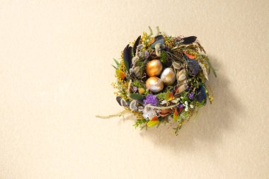 Paskalya 'da hayat. Nazikçe altın bir yüzey üzerinde bir yuvada karışık renkte tavuk taşakları. Tatil konsepti. Uzayı kopyala Kartpostal tasarımı. Metnin altına yerleştir.