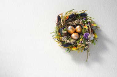 Paskalya 'da hayat. Nazikçe güzel bir yüzeyde, bir yuvada karışık renkte tavuk taşakları. Tatil konsepti. Uzayı kopyala Kartpostal tasarımı. Metnin altına yerleştir.