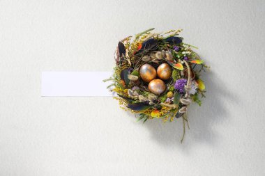 Paskalya 'da hayat. Nazikçe güzel bir yüzeyde, bir yuvada karışık renkte tavuk taşakları. Tatil konsepti. Uzayı kopyala Kartpostal tasarımı. Metnin altına yerleştir.