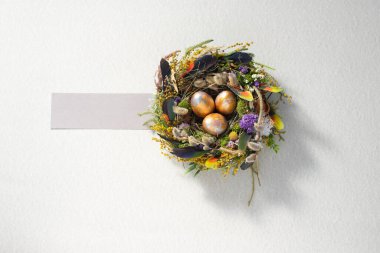 Paskalya 'da hayat. Nazikçe güzel bir yüzeyde, bir yuvada karışık renkte tavuk taşakları. Tatil konsepti. Uzayı kopyala Kartpostal tasarımı. Metnin altına yerleştir.