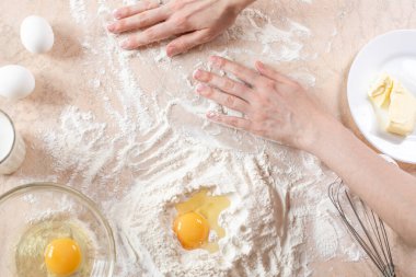 Yemek pişirmek için malzemelerle dolu mutfak masası. Uzayı kopyala Yemek pişirme konsepti. Yumurtalar, arka planda un. Hamur malzemeleri. Üst görünüm.