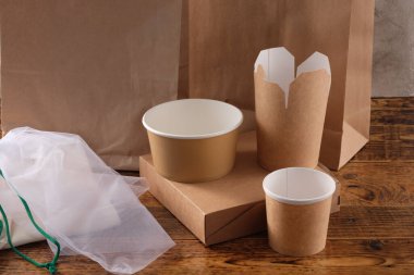 Sokak fast food bardakları, tabaklar ve konteynırlar. Ahşap arka planda çevre dostu gıda ambalajı. Uzayı kopyala Doğanın taşınması ve geri dönüşüm kavramı.