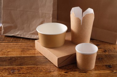 Sokak fast food bardakları, tabaklar ve konteynırlar. Ahşap arka planda çevre dostu gıda ambalajı. Uzayı kopyala Doğanın taşınması ve geri dönüşüm kavramı.