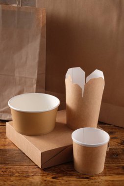Sokak fast food bardakları, tabaklar ve konteynırlar. Ahşap arka planda çevre dostu gıda ambalajı. Uzayı kopyala Doğanın taşınması ve geri dönüşüm kavramı.