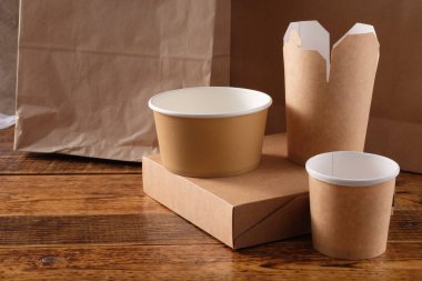 Sokak fast food bardakları, tabaklar ve konteynırlar. Ahşap arka planda çevre dostu gıda ambalajı. Uzayı kopyala Doğanın taşınması ve geri dönüşüm kavramı.