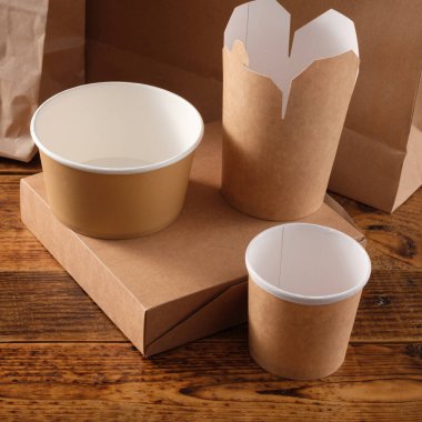Sokak fast food bardakları, tabaklar ve konteynırlar. Ahşap arka planda çevre dostu gıda ambalajı. Uzayı kopyala Doğanın taşınması ve geri dönüşüm kavramı.