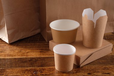 Sokak fast food bardakları, tabaklar ve konteynırlar. Ahşap arka planda çevre dostu gıda ambalajı. Uzayı kopyala Doğanın taşınması ve geri dönüşüm kavramı.