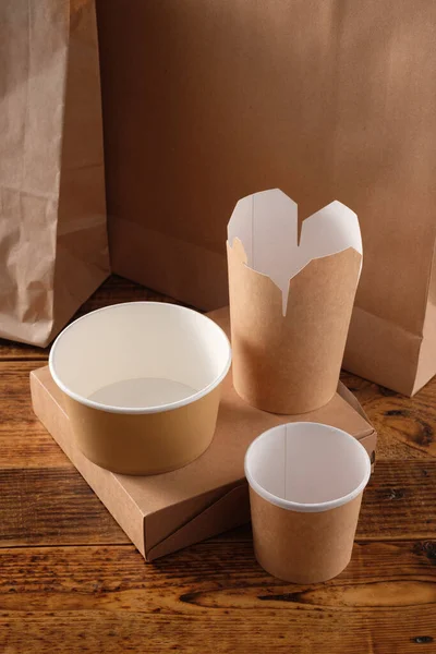 Sokak fast food bardakları, tabaklar ve konteynırlar. Ahşap arka planda çevre dostu gıda ambalajı. Uzayı kopyala Doğanın taşınması ve geri dönüşüm kavramı.