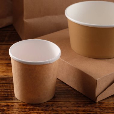 Sokak fast food bardakları, tabaklar ve konteynırlar. Ahşap arka planda çevre dostu gıda ambalajı. Uzayı kopyala Doğanın taşınması ve geri dönüşüm kavramı.