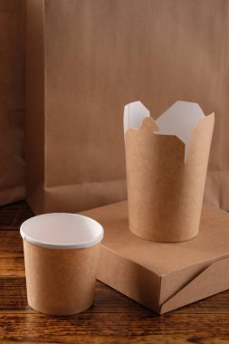 Sokak fast food bardakları, tabaklar ve konteynırlar. Ahşap arka planda çevre dostu gıda ambalajı. Uzayı kopyala Doğanın taşınması ve geri dönüşüm kavramı.