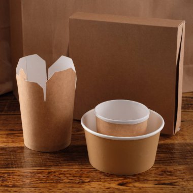 Sokak fast food bardakları, tabaklar ve konteynırlar. Ahşap arka planda çevre dostu gıda ambalajı. Uzayı kopyala Doğanın taşınması ve geri dönüşüm kavramı.