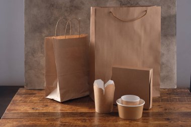 Sokak fast food bardakları, tabaklar ve konteynırlar. Ahşap arka planda çevre dostu gıda ambalajı. Uzayı kopyala Doğanın taşınması ve geri dönüşüm kavramı.